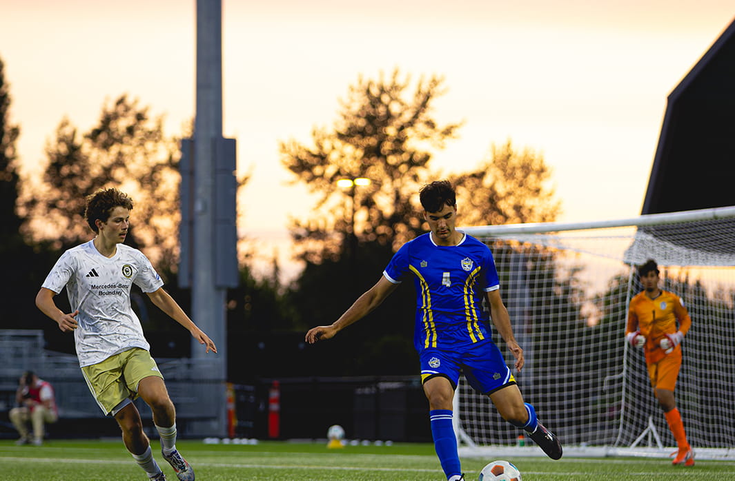 Teens playing soccer on a field